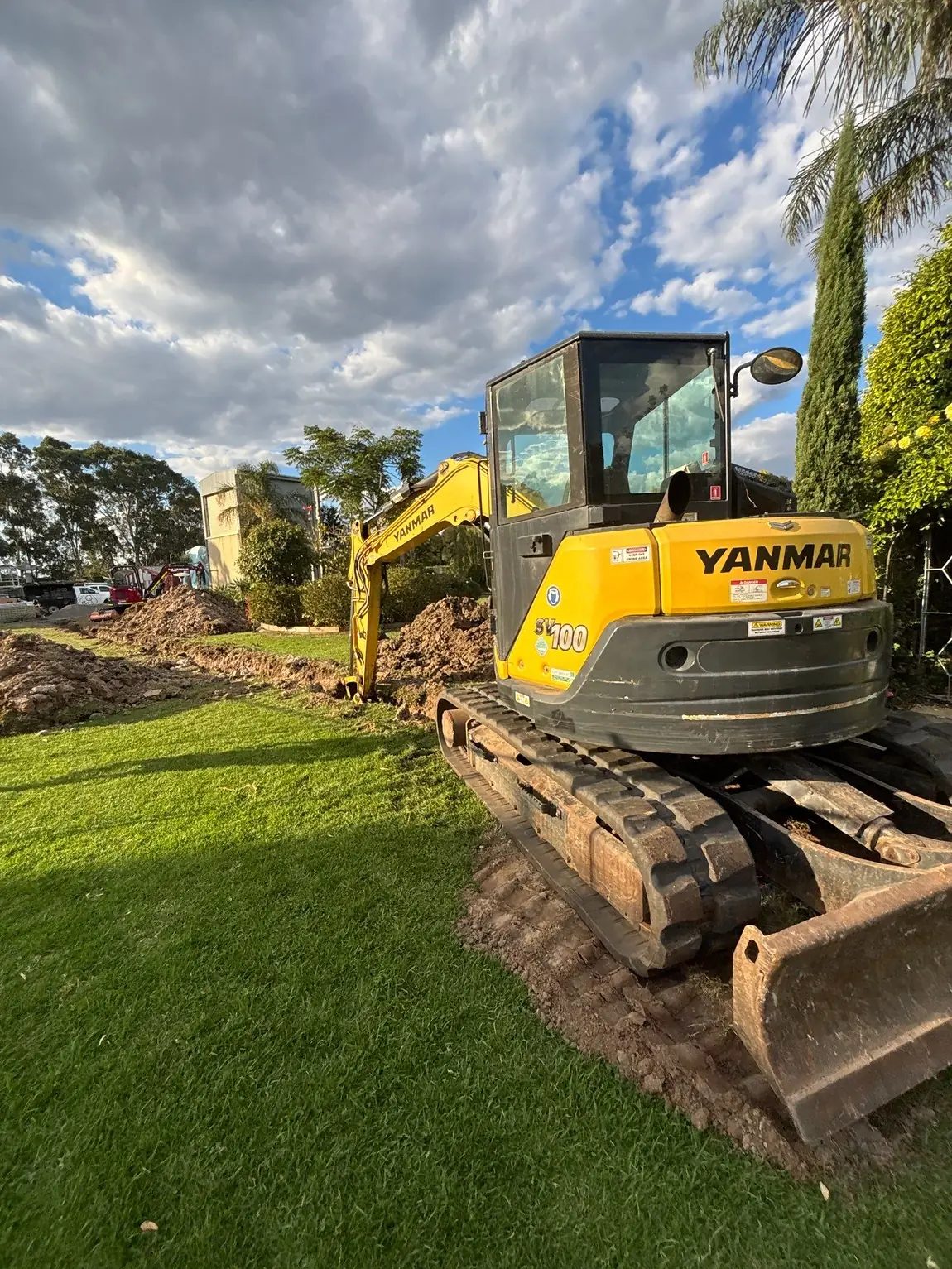 Excavator on a commercial site with trench works underway