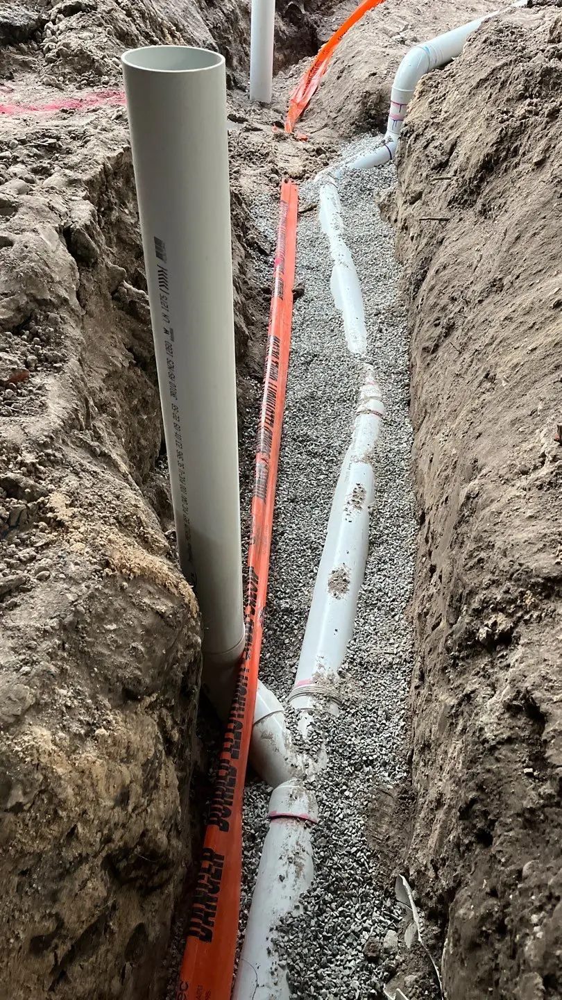Stormwater and sewer pipework bedded on gravel in an open trench