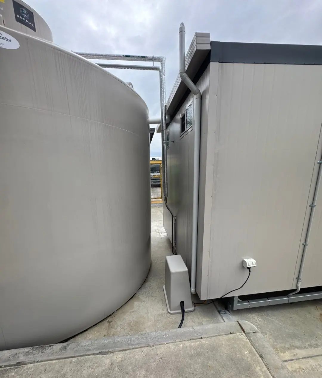 Water storage tank installed alongside a commercial amenities building